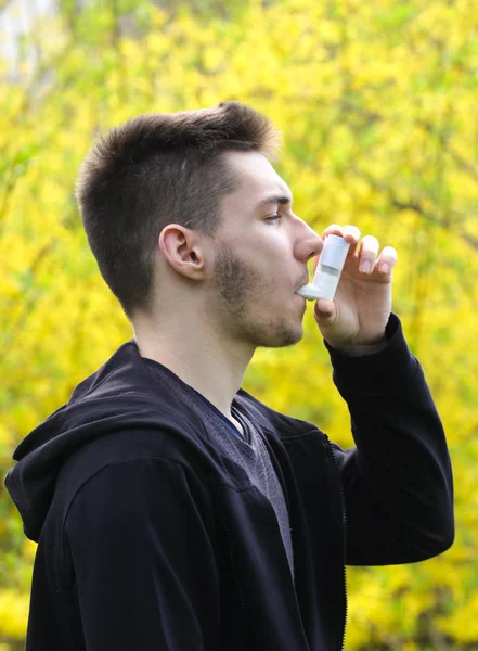 Teenager boy using asthma inhaler in park, Pollen allergy — Stock Photo, Image