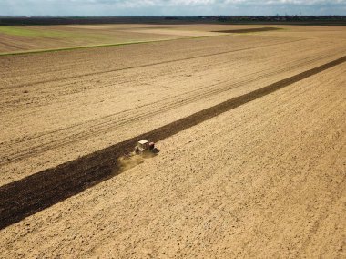 Kırmızı traktör ekim için toprak hazırlanıyor