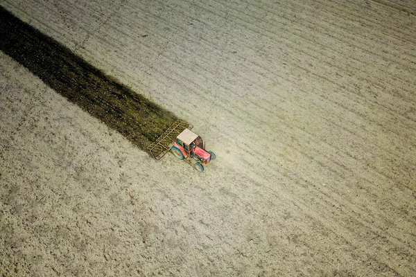 Air view of plowing red tractor