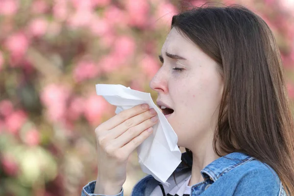 Teeneger girl with polen allergy sneezing in park — Stock Photo, Image