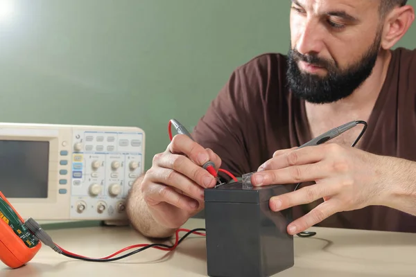 Electricista comprueba la batería en el laboratorio — Foto de Stock