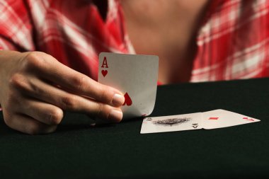 Kumarhanede bir kadının elinde as kart var.