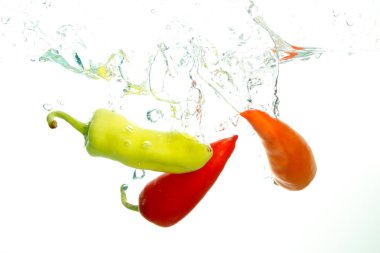 Beyaz üzerine su sıçramaüç kırmızı biber