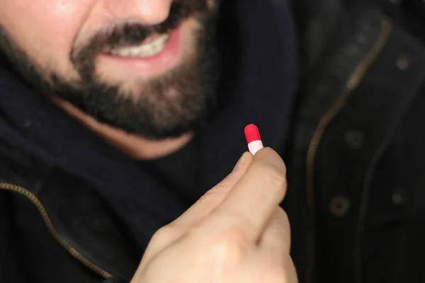 Homem toma comprimidos de ecstasy — Fotografia de Stock