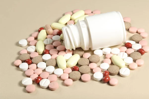 Plast vit flaska och färgglada piller och tabletter — Stockfoto