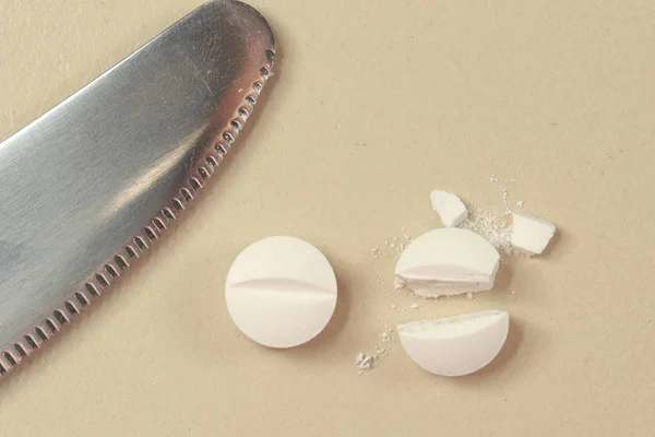 Dosing, bir bıçak ile beyaz antibiyotik tablet yarıya