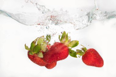 Beyaz arka planda suya sıçramak çilek