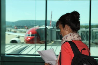 Kadın havaalanında bir uçuş bekliyor
