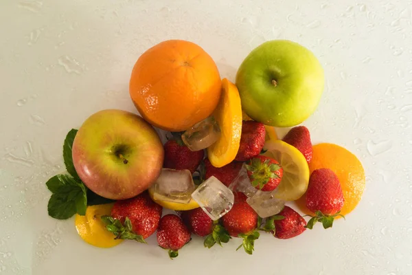 Вид сверху на различные свежие фрукты со льдом — стоковое фото