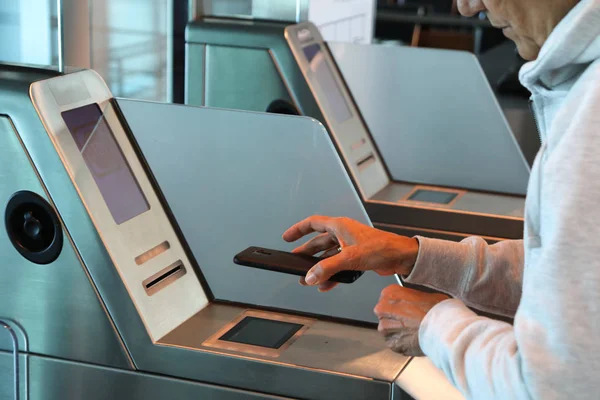 Жінка реєструється зі смартфоном у воріт аеропорту — стокове фото