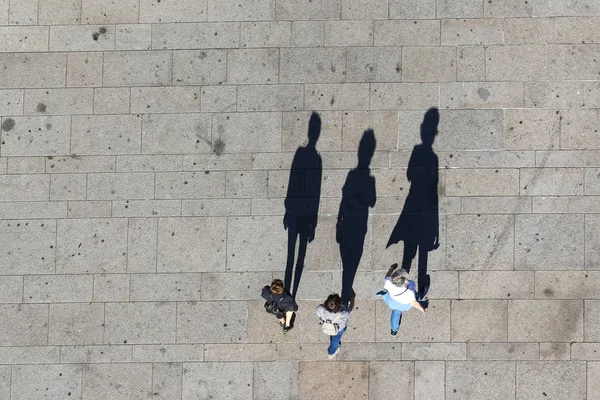 通りに影を持つ3人の観光客のトップビュー — ストック写真