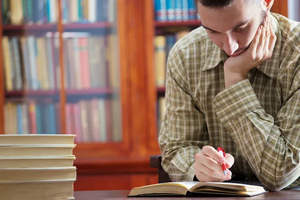 Genç çocuk kütüphanede öğreniyor.