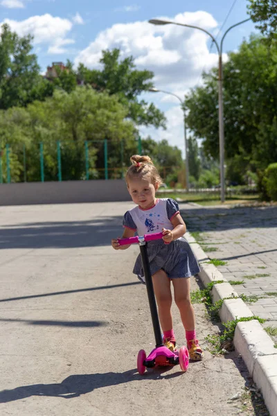 Lindo Niño Patina Hábilmente Una Scooter Rosa Dos Ruedas Día —  Fotos de Stock