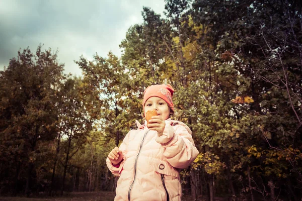 Funny child eating pie in the forest