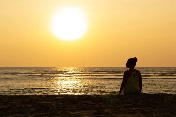 Silueta de una joven mujer en el contexto de la puesta de sol y el gran sol — Foto de Stock