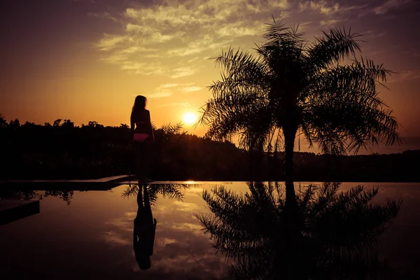 Retrato de una joven de pie contra una hermosa puesta de sol — Foto de Stock