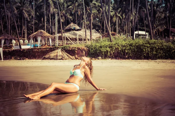 Porträt einer jungen Frau am Strand vor Palmenkulisse — Stockfoto