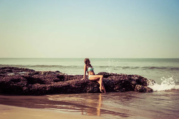 Ritratto di una giovane donna sullo sfondo di onde e pietre — Foto Stock