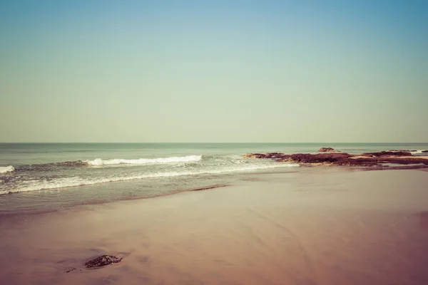 Landscape, beach in the Indian ocean, waves and rocks