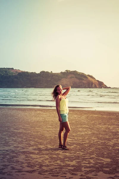 Chica caminando por la playa al atardecer —  Fotos de Stock