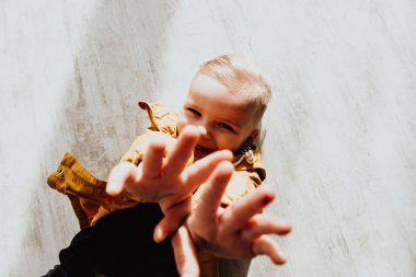 İki yaşındaki havalı hippi çocuk, sonbahar dekorunun süslü fotoğraf sahasında güzel, parlak sonbahar yapraklarıyla poz veriyor. Sıcak atmosfer