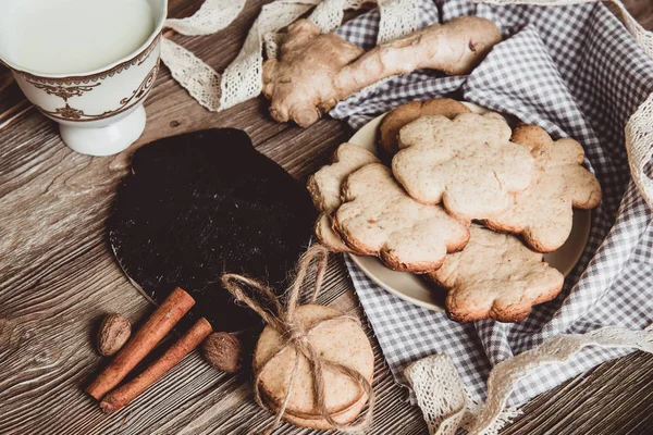 Close up of homemade ginger cookies, cinnamon, ginger on a wooden table. Copy space. Vintage toned image, flat lay