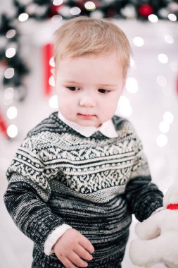 Genç bir çocuğun Noel portresi şöminenin ve Noel ağacının etrafında rahat bir atmosfer.