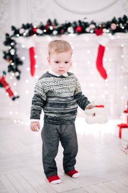 Genç bir çocuğun Noel portresi şöminenin ve Noel ağacının etrafında rahat bir atmosfer.