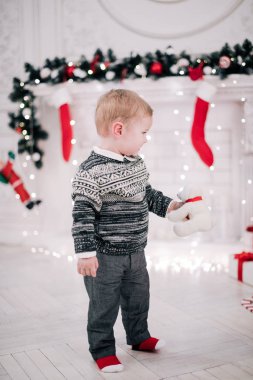 Genç bir çocuğun Noel portresi şöminenin ve Noel ağacının etrafında rahat bir atmosfer.