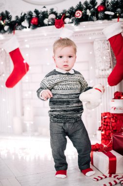 Genç bir çocuğun Noel portresi şöminenin ve Noel ağacının etrafında rahat bir atmosfer.