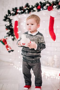 Genç bir çocuğun Noel portresi şöminenin ve Noel ağacının etrafında rahat bir atmosfer.