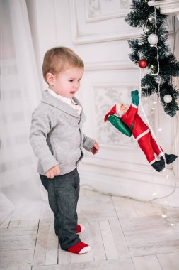 Genç bir çocuğun Noel portresi şöminenin ve Noel ağacının etrafında rahat bir atmosfer.