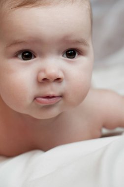 Beyaz odada yatan bebek çocuk portresi