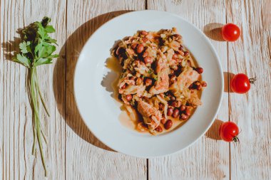 Kiraz domates ve maydanoz ahşap masa üzerinde fasulye güveç