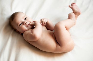 Beyaz odada yatan bebek çocuk portresi