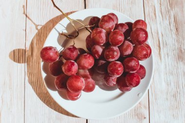 Ahşap masa üzerinde taze kırmızı üzüm yakın çekim