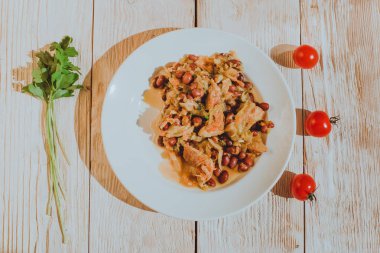 Kiraz domates ve maydanoz ahşap masa üzerinde fasulye güveç