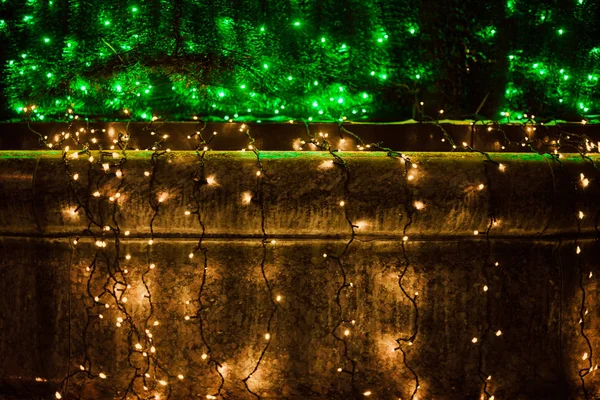 A large Christmas tree with bright garlands and star Shine lights down on the street in winter. Decoration of the city of Gomel, Belarus for the holiday.