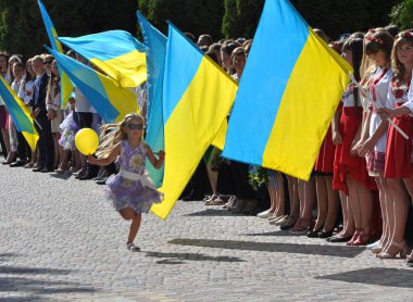 Chortkiv - Ternopil - Ukrayna - 31 Ağustos 2017. Ukrayna Devlet bayrakları çerçevede topuyla kutlamalar sırasında Devlet Pedagoji üniversitede çalışan küçük bir kız 