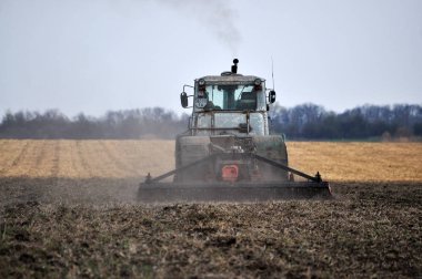 Chortkiv - Ternopil - Ukrayna - 5 Nisan 2017. Disk temizleme çeşitli makineler ile güçlü traktör toprak bahar alan çalışma için hazırlamak.