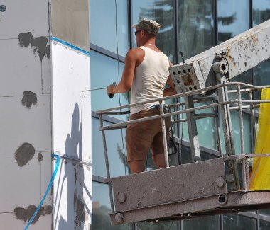 Chortkiv - Ternopil - Ukrayna - 14 Ağustos 2018. İşçi iş yalıtım cephe idari binanın gerçekleştirir