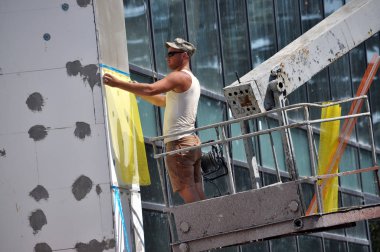 Chortkiv - Ternopil - Ukrayna - 14 Ağustos 2018. İşçi iş yalıtım cephe idari binanın gerçekleştirir