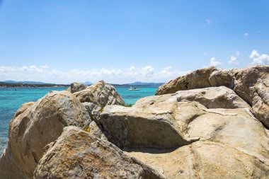Kayaların üzerinde plaj doğal çerçeveleme turkuaz deniz manzarası woth görüntünün merkezinde küçük bir sürat ve birçok diğer küçük adalar amaç, La Maddalena, İtalya Tarih içinde.