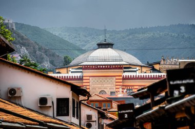 Yeşil tepeli çatılar arasında tarihi kubbeli bina