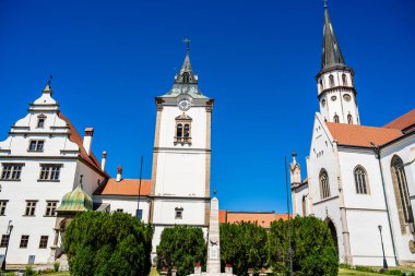 Mavi gökyüzüne karşı yüksek kuleleri olan tarihi beyaz kilise binaları