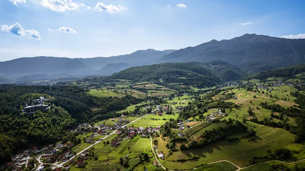 Yükselen yemyeşil vadi uzak sisli dağların altında
