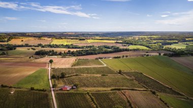 Aerial view showing sprawling rural farmland under clear blue sky
