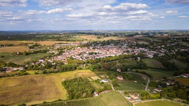 Aerial view showing sprawling rural village among green fields
