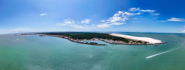 Hava manzarası turkuaz sularla çevrili kıyı adasını gösteriyor.