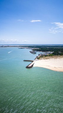 Kıyı şeridi manzaralı mavi gökyüzü sakin denizi gösteriyor.